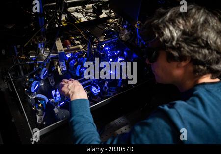 Stuttgart, Deutschland. 03. Mai 2023. Florian Meinert, Gruppenleiter am 5. Institut für Physik der Universität Stuttgart, passt im Labor des Instituts ein Quantenrechner-System mit neutralen Atomen an, in dem ein neues Quantenbit-Konzept auf der neutralen Atom-Plattform erforscht wird. (An dpa: 'Extra-schneller Quantencomputer soll bis 2025 in Stuttgart gebaut werden') Kredit: Marijan Murat/dpa/Alamy Live News Stockfoto