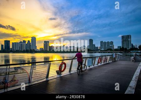 Radfahrer am Riverside Walk of Singapore Sports Hub bei Sonnenuntergang. Es ist ein Sport- und Erholungsviertel in Kallang, Singapur. Stockfoto