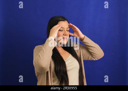 40-jährige Erwachsene Latina-Frau leidet an sehr starken Migräne-Kopfschmerzen aufgrund von hormonellen Veränderungen, Stress und Depressionen Stockfoto