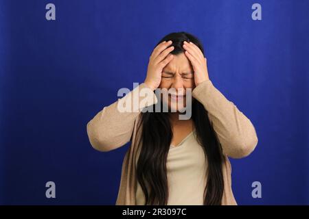 40-jährige Erwachsene Latina-Frau leidet an sehr starken Migräne-Kopfschmerzen aufgrund von hormonellen Veränderungen, Stress und Depressionen Stockfoto