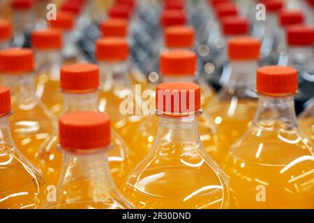 Plastikflaschen mit Süßwasser in Folge, selektiver Fokus. Erfrischungsgetränke in einem Laden Stockfoto