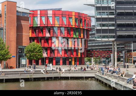 Menschen auf dem Pier in Lindoholmspiren beim roten Kuggan (Zahnrad) Gebäude, Chalmers Universität für Technologie, Lindholmen Campus, am Gota Kanal, Göteborg Stockfoto