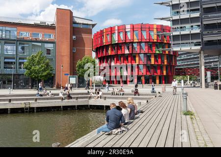 Leute auf dem Pier in Lindoholmspiren beim roten Kuggan (Zahnrad) Gebäude, Chalmers Universität für Technologie, Lindholmen Campus, am Gota Kanal. Göteborg Stockfoto