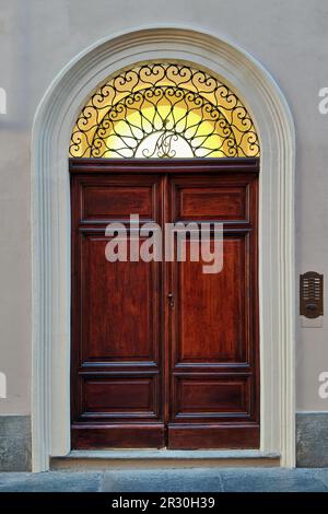 Vorderansicht der Holztür im Torbogen (vertikale Zusammensetzung). Stockfoto