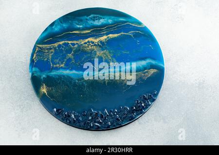 Kunstkomposition aus Harz mit blauen Farben und dunkelblauen Steinen Stockfoto
