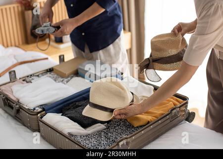 Glückliches reifes chinesisches Paar, das Koffer für den Urlaub packt Stockfoto