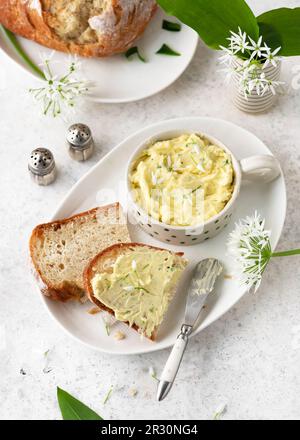 Blick von oben auf Brotscheiben mit hausgemachter Butter aus wilden Knoblauchblumen. Einfache und gesunde Snacks und Aperitif. (Allium ursinum) Stockfoto