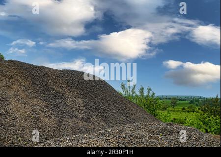 Kleiner Kies aus Granit. Ein großer Haufen Baubasalt in einem Steinbruch. Stockfoto