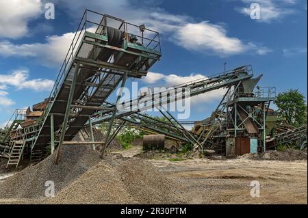 Steinbruchförderer für die Minningindustrie. Brechmaschinen, Kegelsteinbrecher, Förderer von zerdrücktem Granitkiesstein in einem Steinbruch-Minin Stockfoto