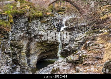 Der Linn O’ Dee, wo der Fluss Dee durch eine felsige Schlucht donnert, die von einer alten Steinbrücke in der Nähe von Braemar in Aberdeenshire, Schottland, Vereinigtes Königreich, umgeben ist Stockfoto