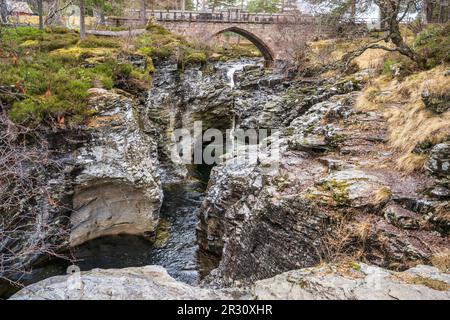 Der Linn O’ Dee, wo der Fluss Dee durch eine felsige Schlucht donnert, die von einer alten Steinbrücke in der Nähe von Braemar in Aberdeenshire, Schottland, Vereinigtes Königreich, umgeben ist Stockfoto