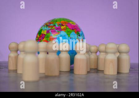 Holzpuppen und Erdkugel. Weltbevölkerungstag-Konzept Stockfoto