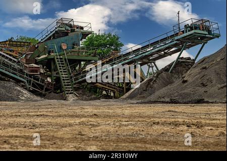 Steinbruchförderer für die Minningindustrie. Brechmaschinen, Kegelsteinbrecher, Förderer von zerdrücktem Granitkiesstein in einem Steinbruch-Minin Stockfoto