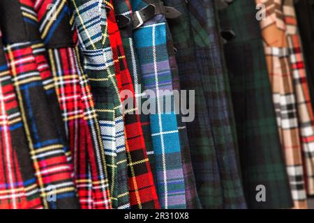 Tartan-Kilts-Hintergrund. Selektiver Fokus auf traditionelles schottisches Kleid in einer Vielzahl traditioneller Farben und Designs. Stockfoto