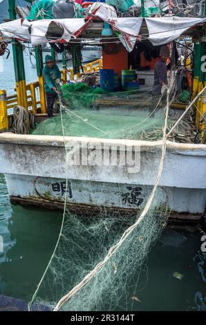Taipeh. 22. Mai 2023. Am 22. März 05/2023 hissen Fischer Fischernetze auf ein Fischereifahrzeug, das am Kai des Fischereihafens Tamsui in New Taipei City, Taiwan, vor Anker liegt, und zwar von Wiktor Dabkowski Credit: dpa/Alamy Live News Stockfoto