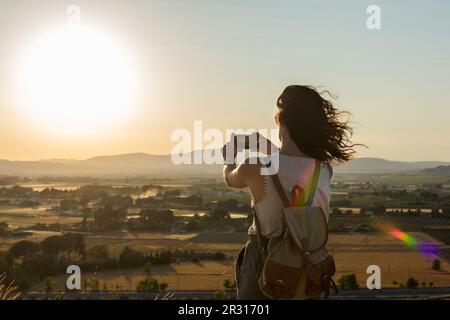 Eine junge Frau macht ein Foto mit ihrem Smartphone auf einem Berg Stockfoto