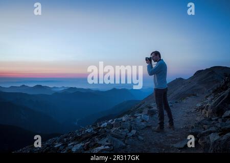 Ein Mann macht Fotos von den Evening Mountains in Mt. Rainier NP Stockfoto
