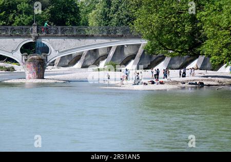 München, Deutschland. 22. Mai 2023. Eine Gruppe von Menschen steht am Ufer der Isar in der Sonne auf einer Kiesbank. Kredit: Sven Hoppe//dpa/Alamy Live News Stockfoto