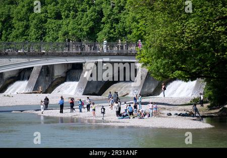 München, Deutschland. 22. Mai 2023. Eine Gruppe von Menschen steht am Ufer der Isar in der Sonne auf einer Kiesbank. Kredit: Sven Hoppe//dpa/Alamy Live News Stockfoto