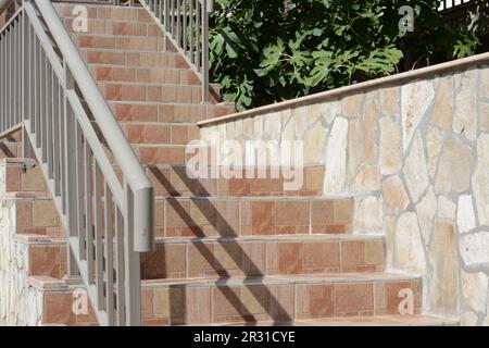 Wunderschöne geflieste Treppen mit Metallgeländern im Freien Stockfoto