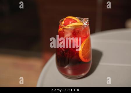 Nahaufnahme eines Sommercocktails mit Orangen- und Erdbeerscheiben auf einem Tisch Stockfoto