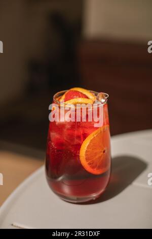 Nahaufnahme eines Sommercocktails mit Orangen- und Erdbeerscheiben auf einem Tisch Stockfoto