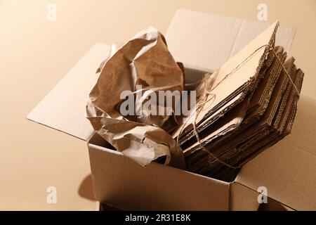 Altpapierhaufen in der Nähe der beigen Wand, geschlossen Stockfoto