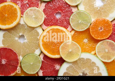Scheiben verschiedener Zitrusfrüchte als Hintergrund, Draufsicht Stockfoto