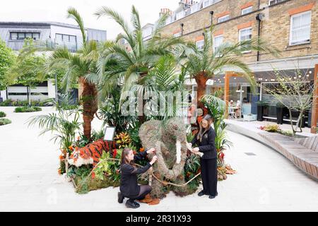 REDAKTIONELLE FLORISTEN von Neill Strain Floral Couture haben der Blumeninstallation „Safari in the City“ in Halkin Arcade in London den letzten Schliff gegeben, die für das Belgravia in Bloom Festival vom 22. Bis 29. Mai in London entworfen wurde. Foto: Montag, 22. Mai 2023. Stockfoto