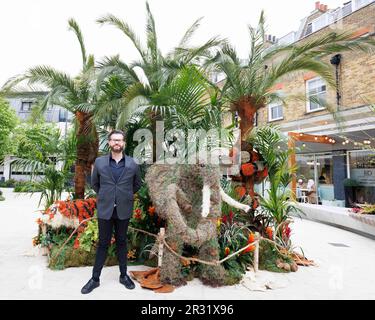 REDAKTIONELLE VERWENDUNG NUR Florist Neill Strain posiert mit seiner Blumeninstallation „Safari in the City“ in der Halkin Arcade in London, die für das Belgravia in Bloom Festival vom 22. Bis 29. Mai in London entworfen wurde. Foto: Montag, 22. Mai 2023. Stockfoto