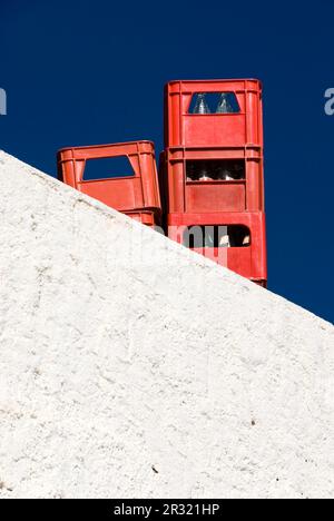 Gestapelte Getränkekisten hinter der weißen Wand Stockfoto