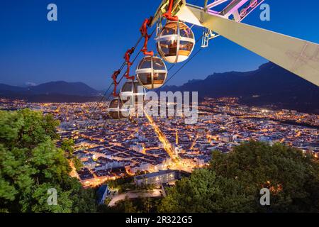 Seilbahn Grenoble-Bastille (bekannt als Les Bulles) mit erhöhtem Blick auf die Stadt Grenoble am Abend. Isere (38), Frankreich Stockfoto