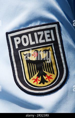 Polizeimarke mit Bundesadler auf blauem Hemd Stockfoto