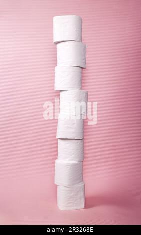 Hoher Toilettenpapierturm aus 8 gestapelten weißen Papierrollen, isoliert auf Pink. Eine Menge Hygienevorräte für Badezimmer oder Toiletten, die von einer Hure aufbewahrt werden Stockfoto