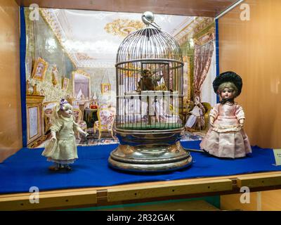 Sergijew Posad, Russland - 21. Mai 2023: Mechanischer Vogel im Käfig und Vintage-Puppen im künstlerischen und pädagogischen Spielzeugmuseum mit dem Namen N D Bartram in Sergiev P. Stockfoto