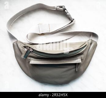 Geschlossene grüne Gürteltasche aus Leder auf grauem Brett, Nahaufnahme Stockfoto