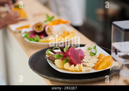 Teller mit geschnittenem reifem Obst auf der Theke im Café Stockfoto