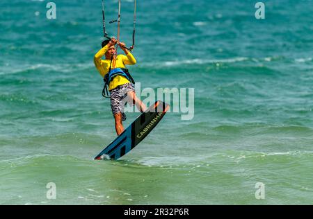 Ein Kitesurfer hebt sich vom Wasser am Strand in Mui Ne, Vietnam ab. Stockfoto