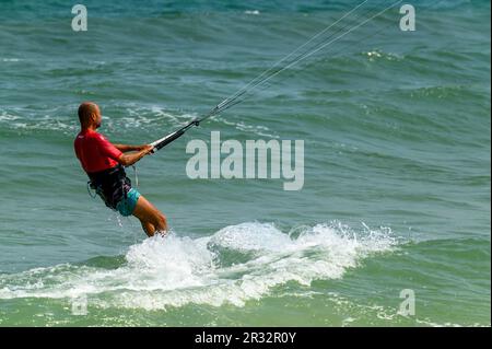 Ein Kitesurfer bei der Einführung seiner Fahrt direkt am Strand in Mui Ne, Vietnam. Stockfoto