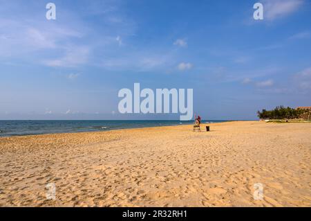 Strandszene mit leerem Liegestuhl am verlassenen Strand am frühen Morgen in Mui Ne, Vietnam. Stockfoto