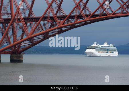 South Queensferry, Schottland, Großbritannien. 22. Mai 2023 Juwel of the Seas, ein 90.000 Tonnen, 965 Fuß großer Kreuzfahrtschiff mit 12 Passagierdecks und ausgestattet mit eigenem Wasserpark, Theater, Casino, Aufzügen und Felskletterwand, kam heute Morgen in der vierten Flussmündung an, um einen seltenen Zwischenstopp zu machen. Sie liegt neben der vierten Brücke, wodurch das Gefühl der Größe gewürdigt werden kann. Kredit: Craig Brown/Alamy Live News Stockfoto