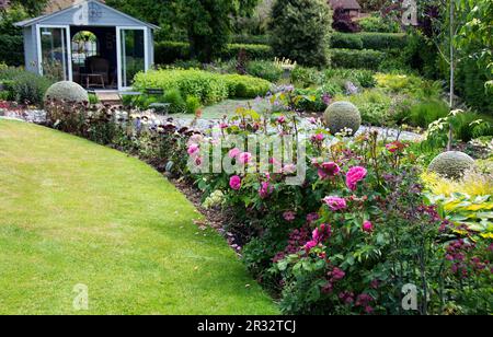 Markante Schieferkugeln und Rosen sind im Caythorpe Open Garden zu sehen Stockfoto