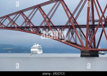 South Queensferry, Schottland, Großbritannien. 22. Mai 2023 Juwel of the Seas, ein 90.000 Tonnen, 965 Fuß großer Kreuzfahrtschiff mit 12 Passagierdecks und ausgestattet mit eigenem Wasserpark, Theater, Casino, Aufzügen und Felskletterwand, kam heute Morgen in der vierten Flussmündung an, um einen seltenen Zwischenstopp zu machen. Sie liegt neben der vierten Brücke, wodurch das Gefühl der Größe gewürdigt werden kann. Kredit: Craig Brown/Alamy Live News Stockfoto