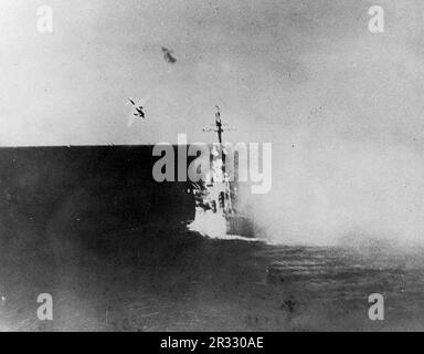 Ein japanisches Kamikaze-Flugzeug taucht in den USA Navy Light Cruiser USS Columbia (CL-56) um 1729 Uhr am 6. Januar 1945 während der Operation am Lingayen Golf. Dieses Flugzeug traf das Hauptdeck beim Pistolenturm, was schwere Schäden und Todesopfer verursachte. Das Flugzeug und seine Bombe durchdrangen zwei Decks, bevor es explodierte, töteten 13 und verwundeten 44. Als Japan Ende 1944 mit einer Niederlage konfrontiert war, entschied es sich, US-Schiffe mit Selbstmordattentaten, bekannt als Kamikaze, zu zerstören. Diese Angriffe waren eine starke physische und psychologische Waffe und versenkten insgesamt 47 Schiffe zu einem Preis von mehr als 3000 Piloten und Flugzeugen. Bis Ende 19 Stockfoto