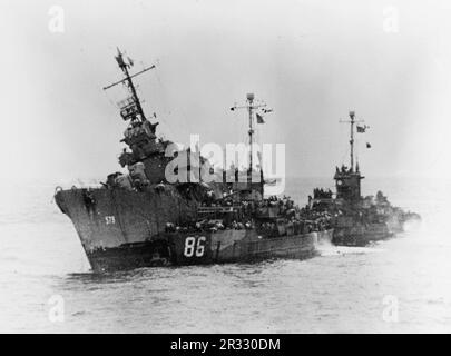 Die USA Navy Destroyer USS William D. Porter (DD-579) sinkt, nachdem sie von einem „Kamikaze“-Selbstmordflugzeug vor Okinawa fast verfehlt wurde, 10. Juni 1945. USS LCS-86 und ein weiterer LCS sind nebenan und nehmen ihre Crew ab. Obwohl William D. Porter nicht vom feindlichen Flugzeug getroffen wurde, erlitt er tödliche Unterwasserschäden durch die nahe gelegene Explosion. Stockfoto