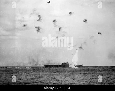 Die USA Flugzeugträger USS Enterprise (CV-6) der Marine in Flammen, nachdem das Schiff am 14. Mai 1945 vor Kyushu von einem Kamikaze getroffen wurde. Der Fahrstuhl, der viele Tonnen wiegt, ist von der Explosion überschwemmt. Stockfoto