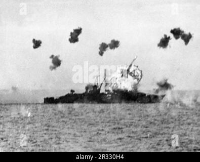 Die USA Der Navy Heavy Cruiser USS Louisville (CA-28) wird am 6. Januar 1945 von einem Kamikaze in Lingayen Gulf auf den Philippinen getroffen. Das Flugzeug war ein Mitsubishi Ki-51. 43 Männer wurden getötet und mindestens 125 verwundet. Konteradmiral Theodore E. Chandler, Kommandeur der Kreuzerdivision 4 (CruDiv 4), war unter den Toten, als er Seeleuten half, die Feuerlöschschläuche zu bedienen, um die massiven Flammen während des Angriffs zu löschen. Als Japan Ende 1944 mit einer Niederlage konfrontiert war, entschied es sich, US-Schiffe mit Selbstmordattentaten, Kamikaze genannt, zu zerstören.Diese Angriffe waren ein starkes physisches und psychologisches Weh Stockfoto
