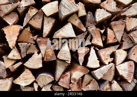 Textur des gehackten Holzes. Holz zum Verbrennen im Herd oder Kamin. Hintergrund des Haufens von Holzstücken. Stockfoto