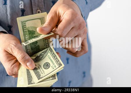Ein Mann überreicht einen dicken Haufen Dollar. Bestechung Stockfoto
