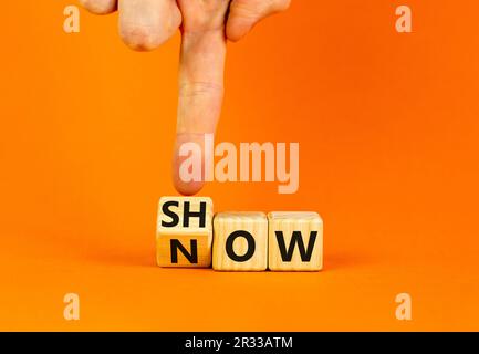 Symbol „Jetzt anzeigen“. Ein Geschäftsmann verwandelt Holzwürfel und ändert das Wort "Show" in "Jetzt". Schöner orangefarbener Tischhintergrund. Speicherplatz kopieren. Business und S Stockfoto